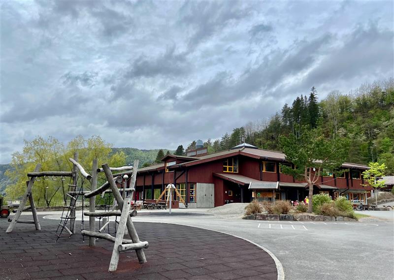 Åseral skule med leikeapparat i forgrunn