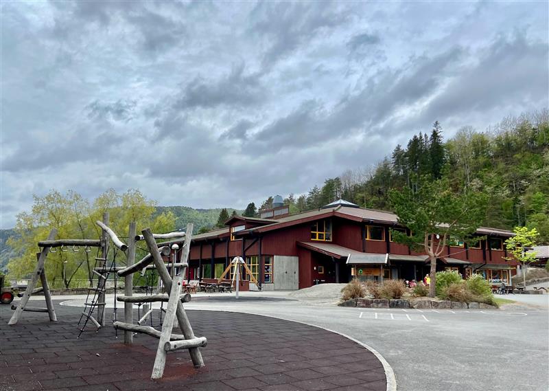 Åseral skule med leikeapparat i forgrunn
